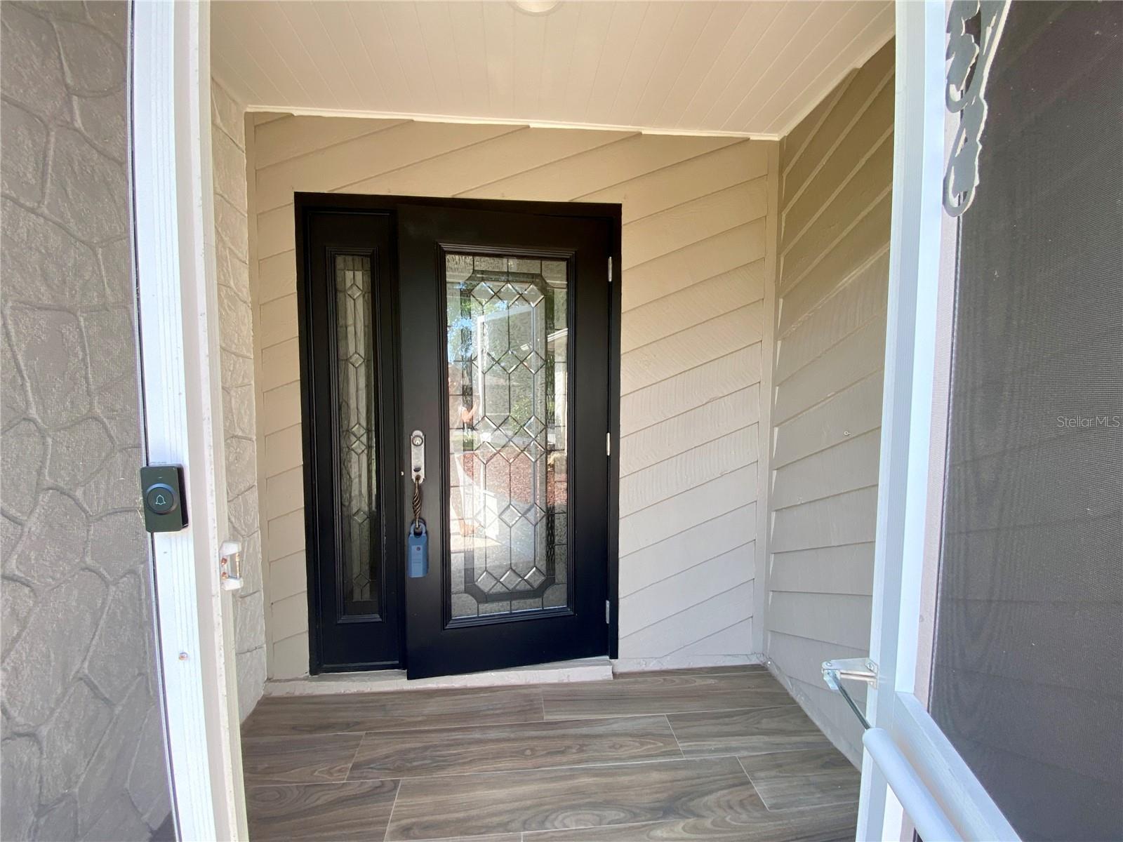 The screened in porch has same tile as the house