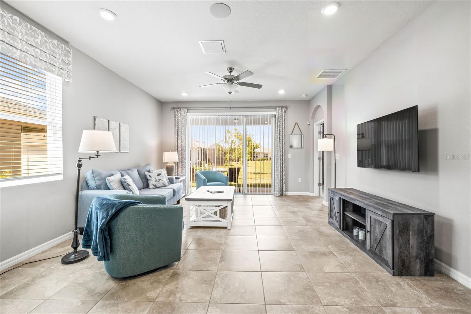 The living room has overhead fan, sliding glass doors and private views in the back.