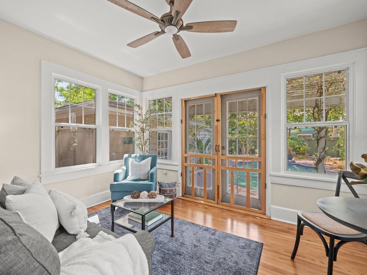 Delightful sunroom overlooking the pool and lush backyard.