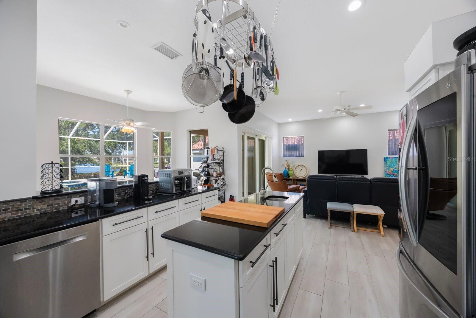 Kitchen has eat-in bar, handing pot rack, plenty of cabinet and counter space, closet pantry