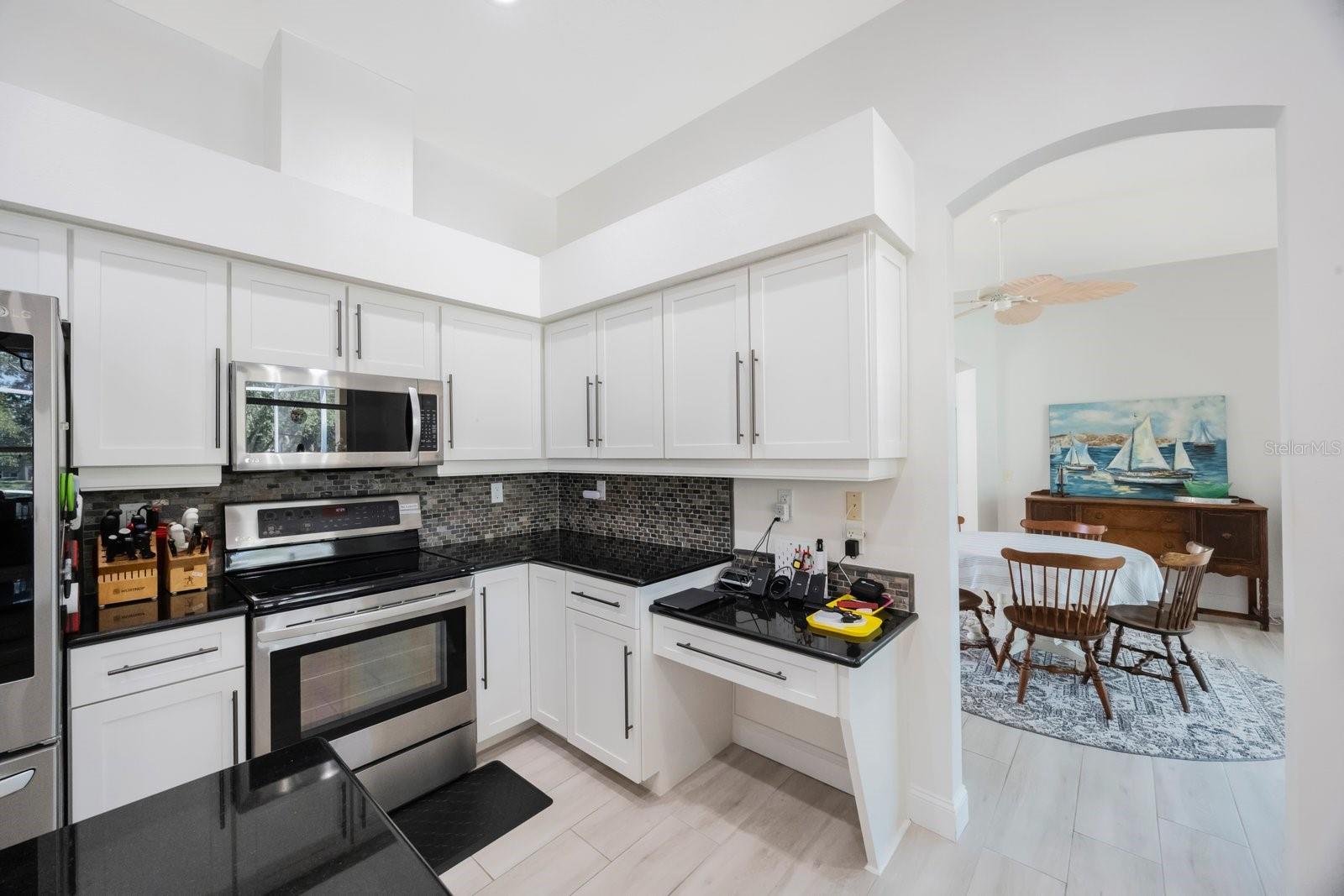 Black granite countertops and white Shaker cabinets have a very contemporary look