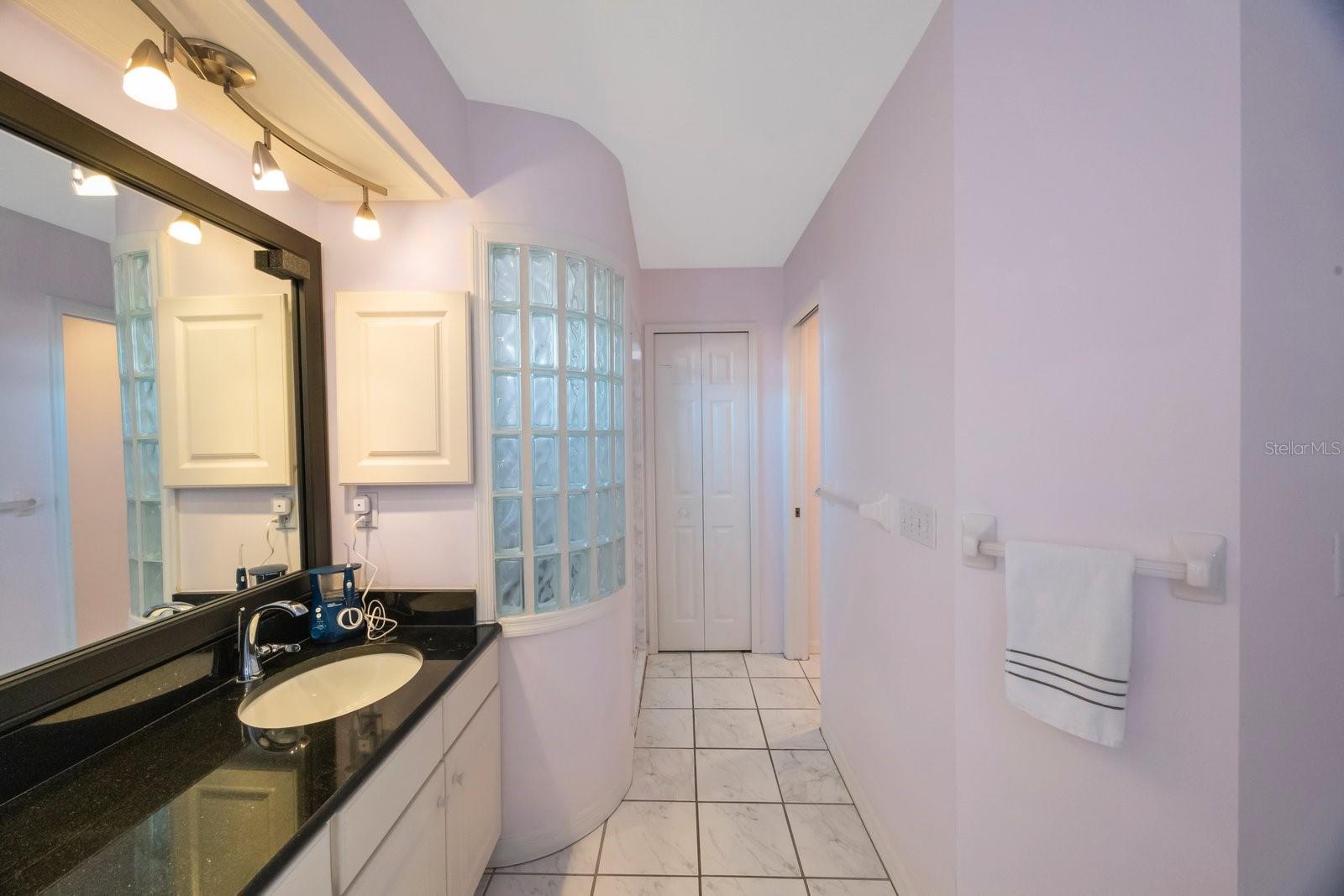 stand-up shower to left, closet with laundry chute to washer straight ahead, water closet on right