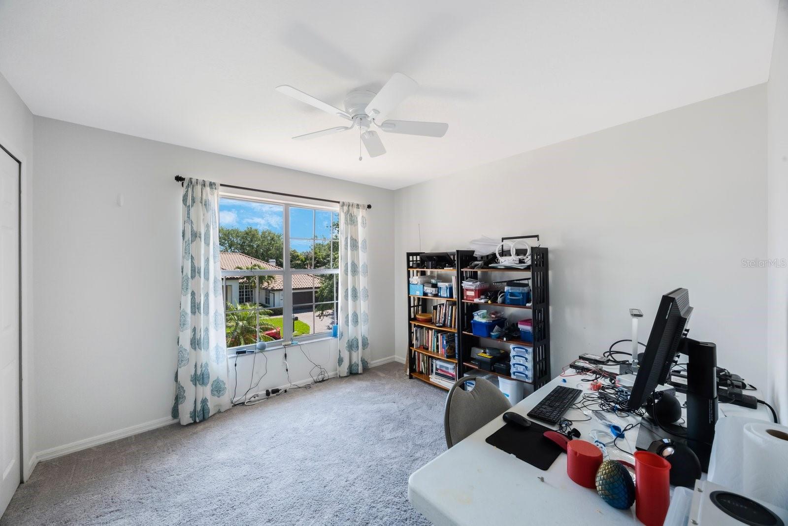 Third bedroom with large closet, wide open window lets in plenty of light.  Currently being used as a computer station.