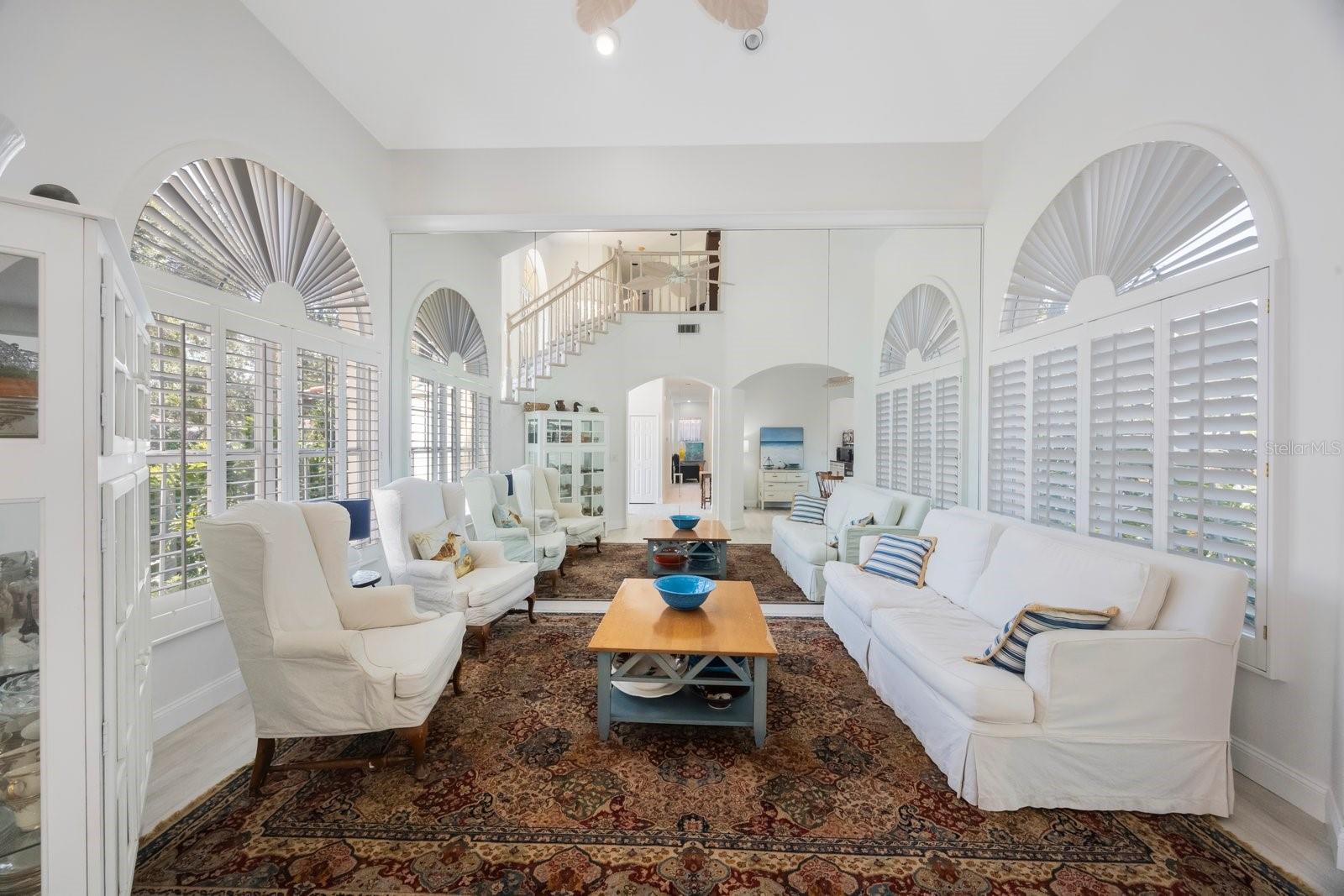 Living room with mirrored wall  and Plantation shutters on all windows