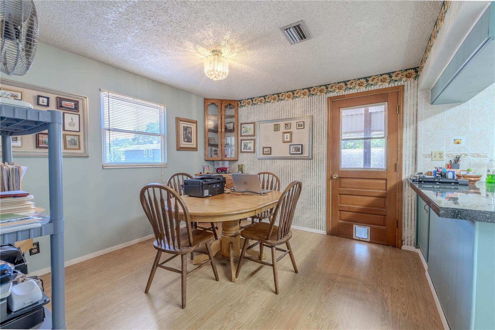 The dinette is open to the kitchen and has wood look laminate flooring.
