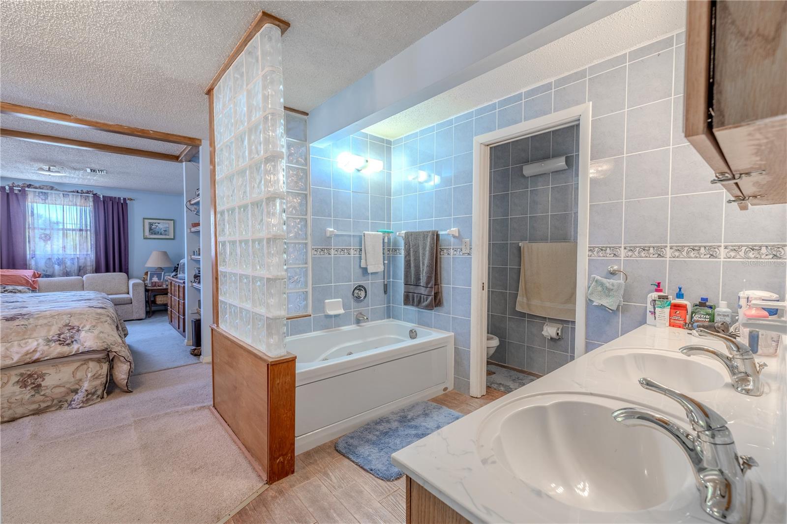 The primary bedroom features a dual sink vanity, hydro tub and a private water closet.