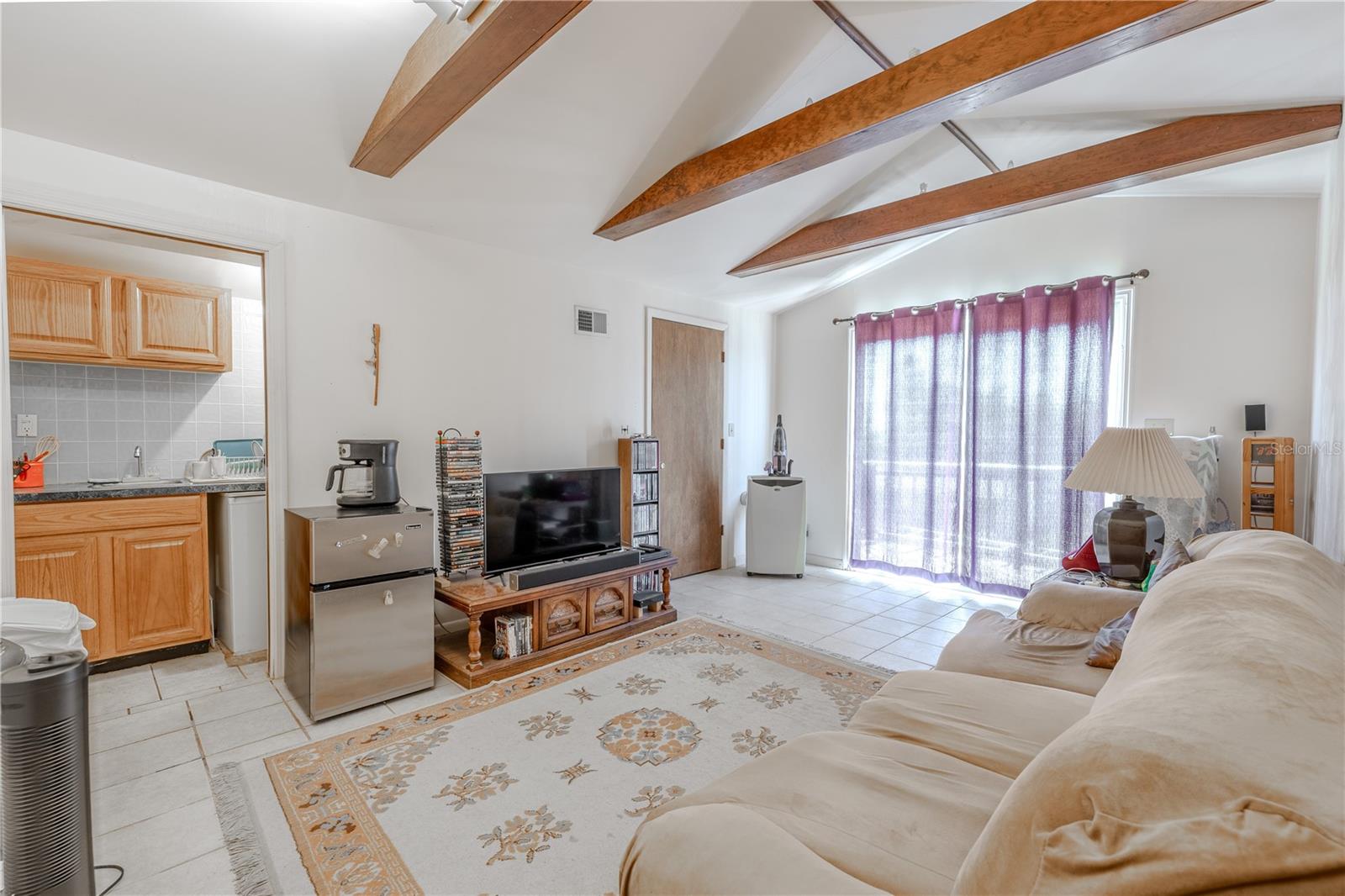 3rd floor has a bonus room with kitchenette, tile floor, beam ceiling , a walk-in closet and balcony.