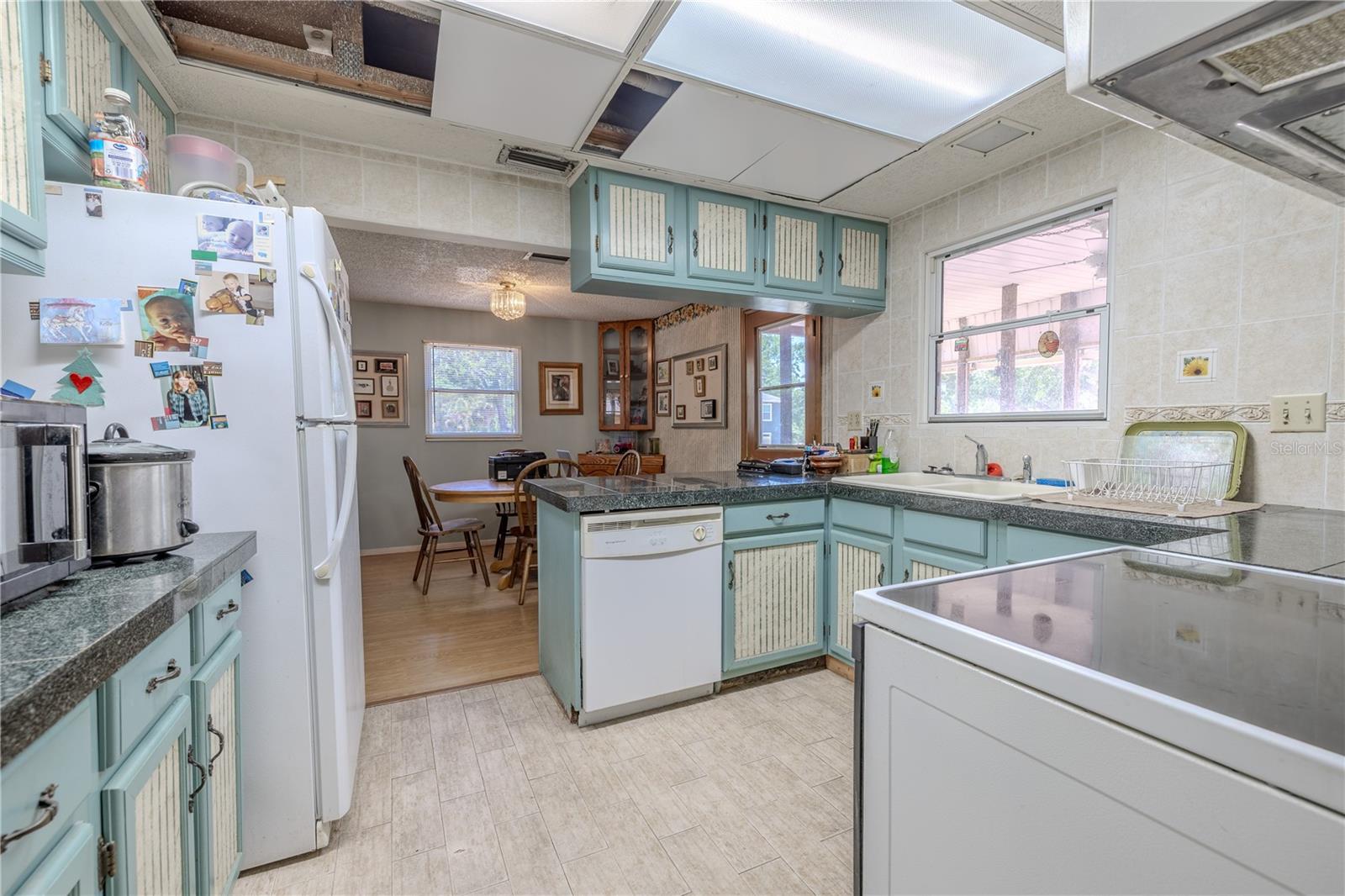 The kitchen features a refrigerator, dishwasher, range and microwave.