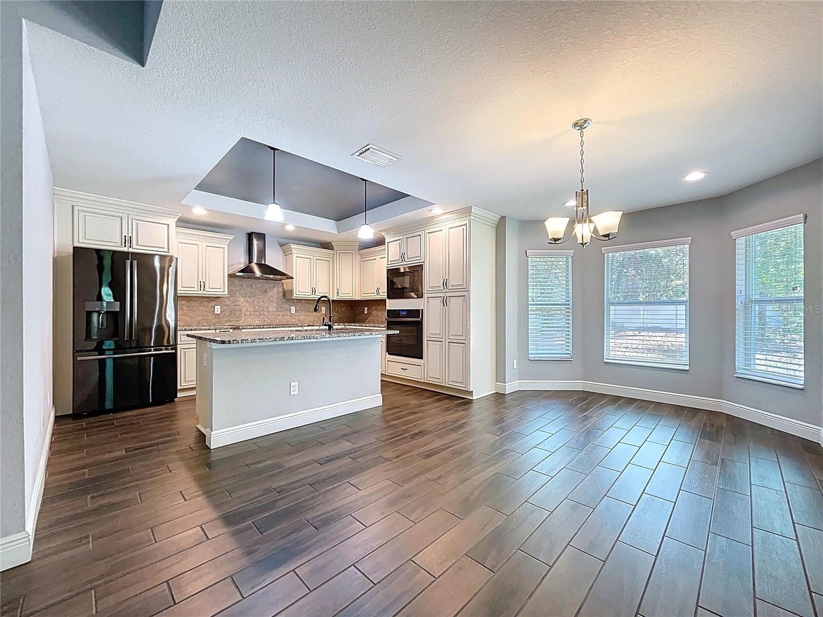 Kitchen overlooks dining area with backyard views.
