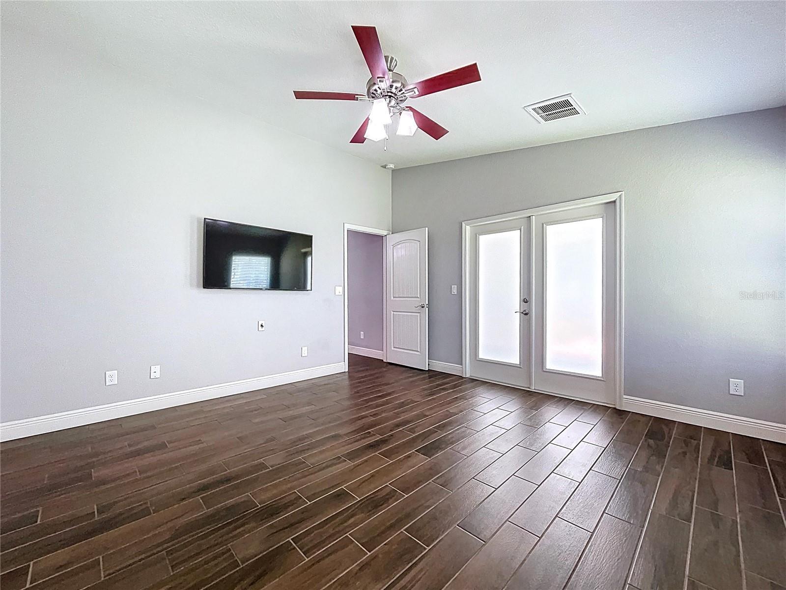 Primary suite features high ceilings and French doors.