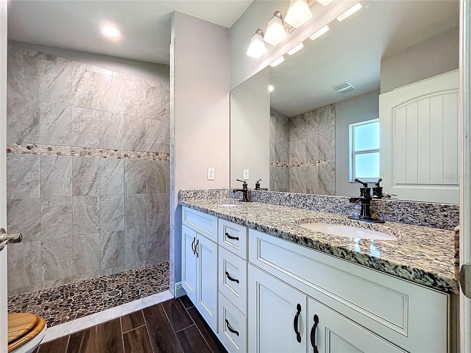 Primary bath with granite counters and dual sinks.