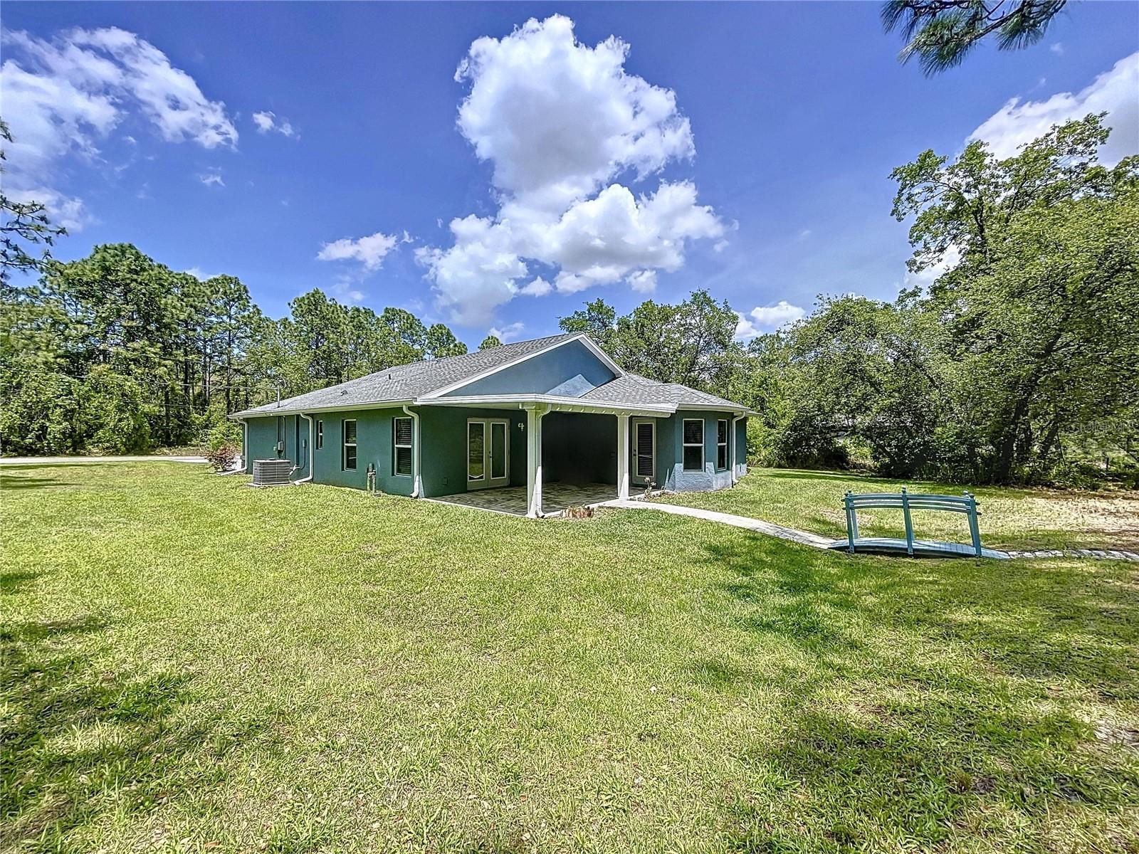 Spacious backyard with paver walkway.