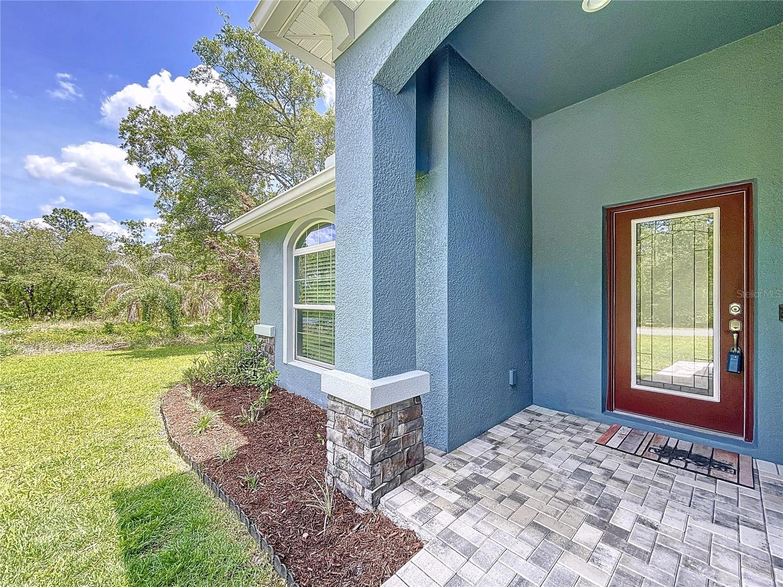 Front entry with paver bricks and glass door.