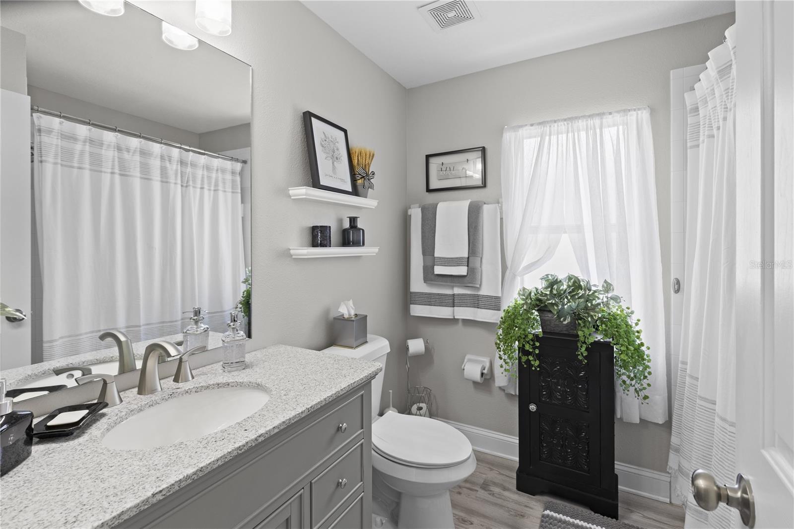 Guest bathroom with tub shower and updated vanity