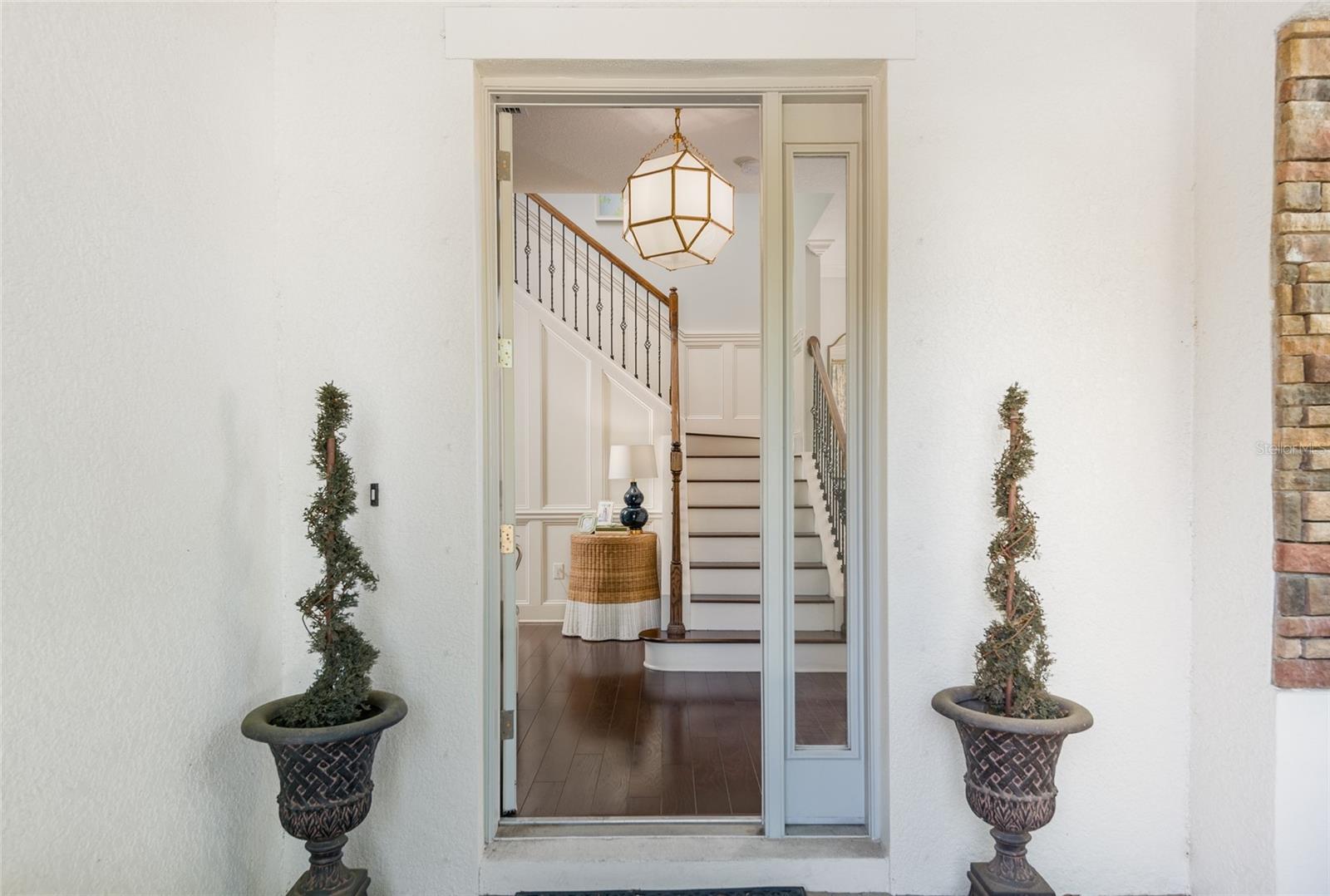 Beautiful entry with wainscoting up the hardwood staircase