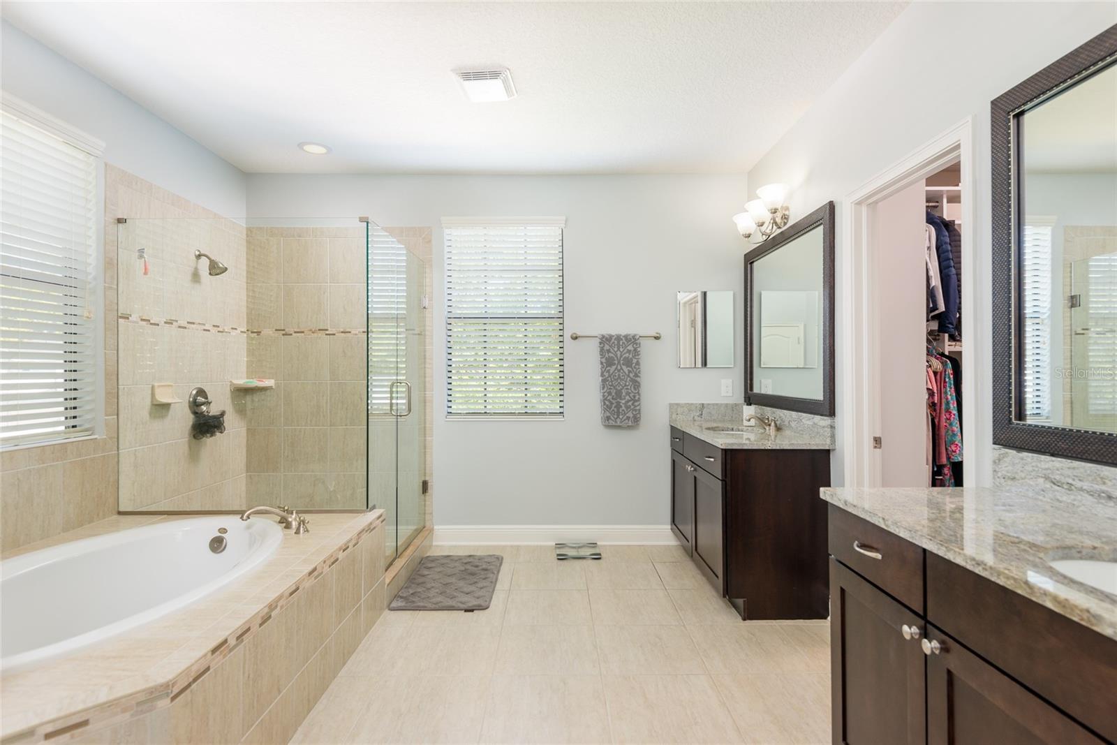 Large primary bathroom with dual sinks, toilet closet, walk in shower and tub.