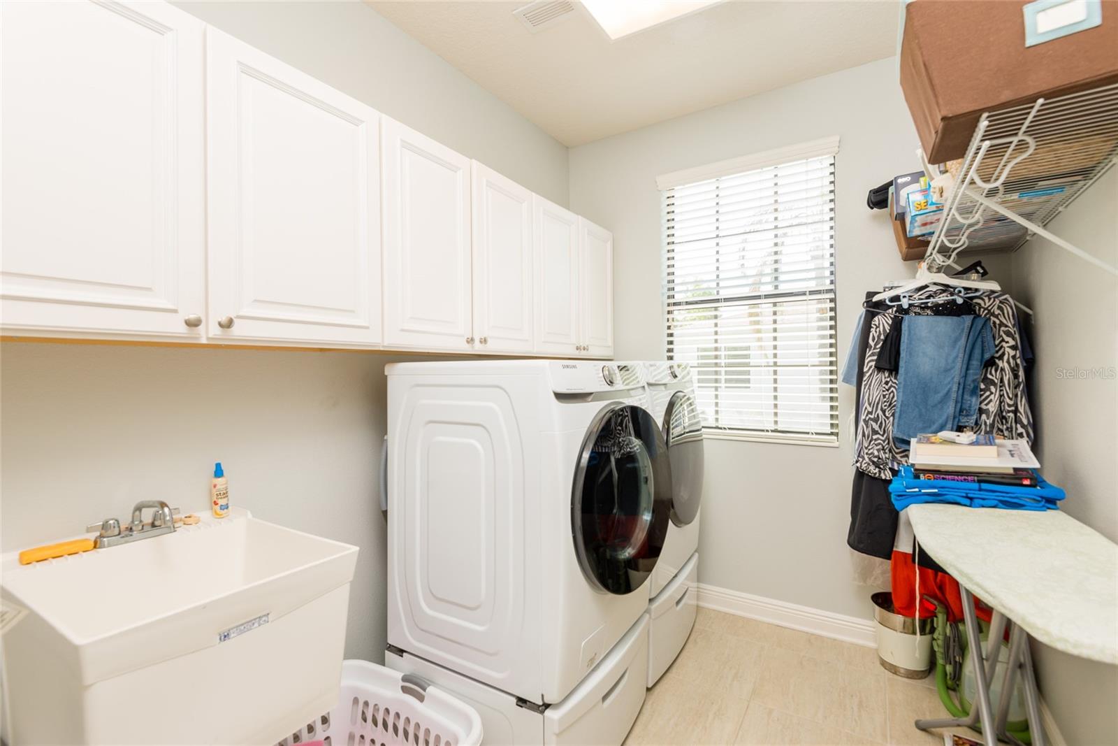 Upstairs laundry room with sink and storage.
