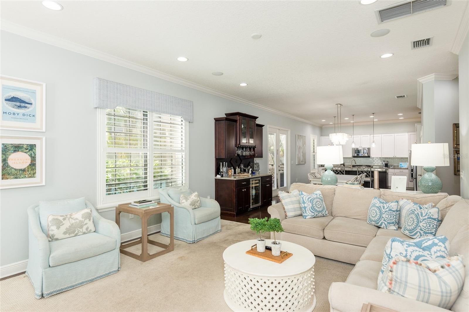 Large family room open to the kitchen and custom built dry bar with beverage fridge.