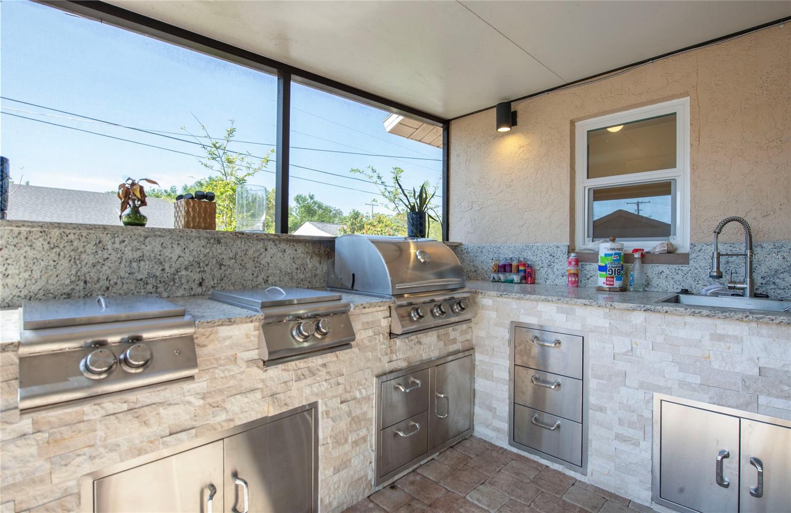 check out this totally equipped outdoor kitchen, grill and 4 burners with sink, lots of cabinets and drawers, and refrigerator