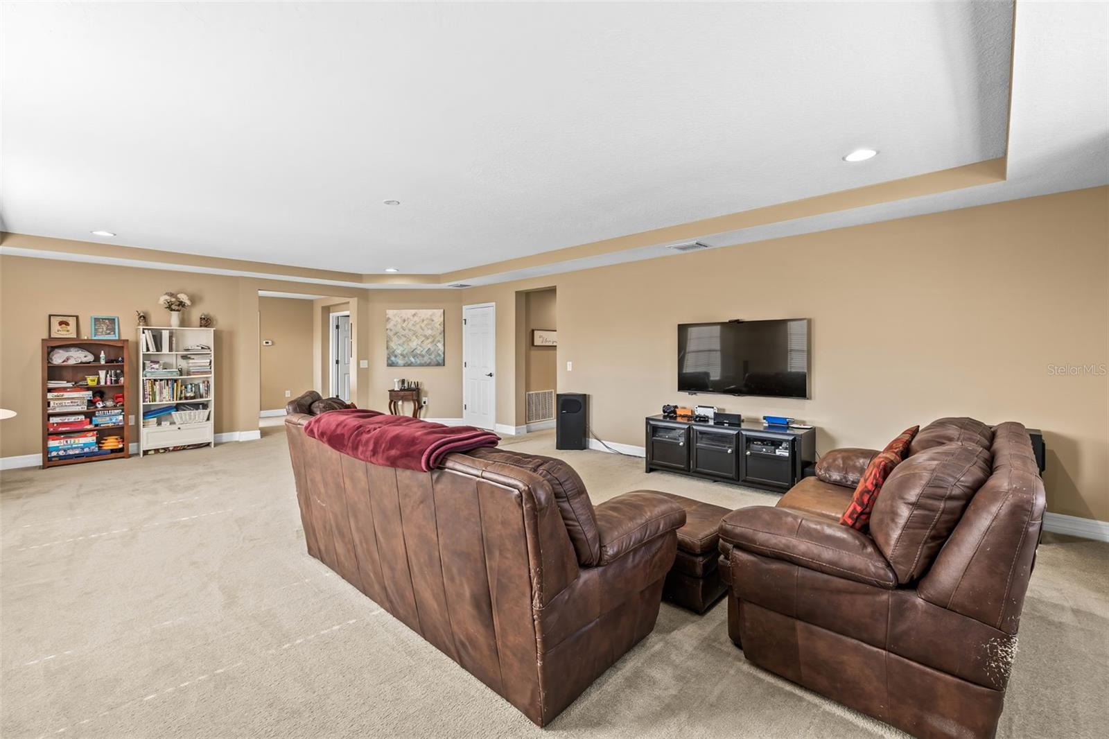 Flex room/ media room has tray ceiling and separates the primary from 3 additional bedrooms.