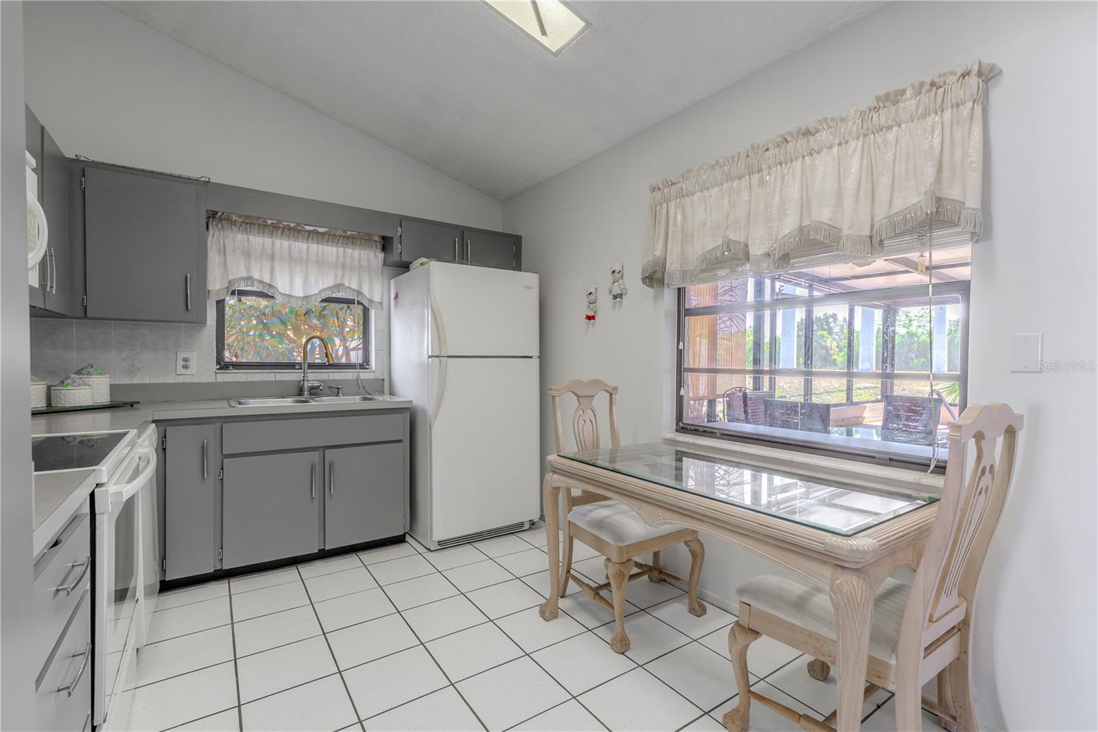 The kitchen features a vaulted ceiling