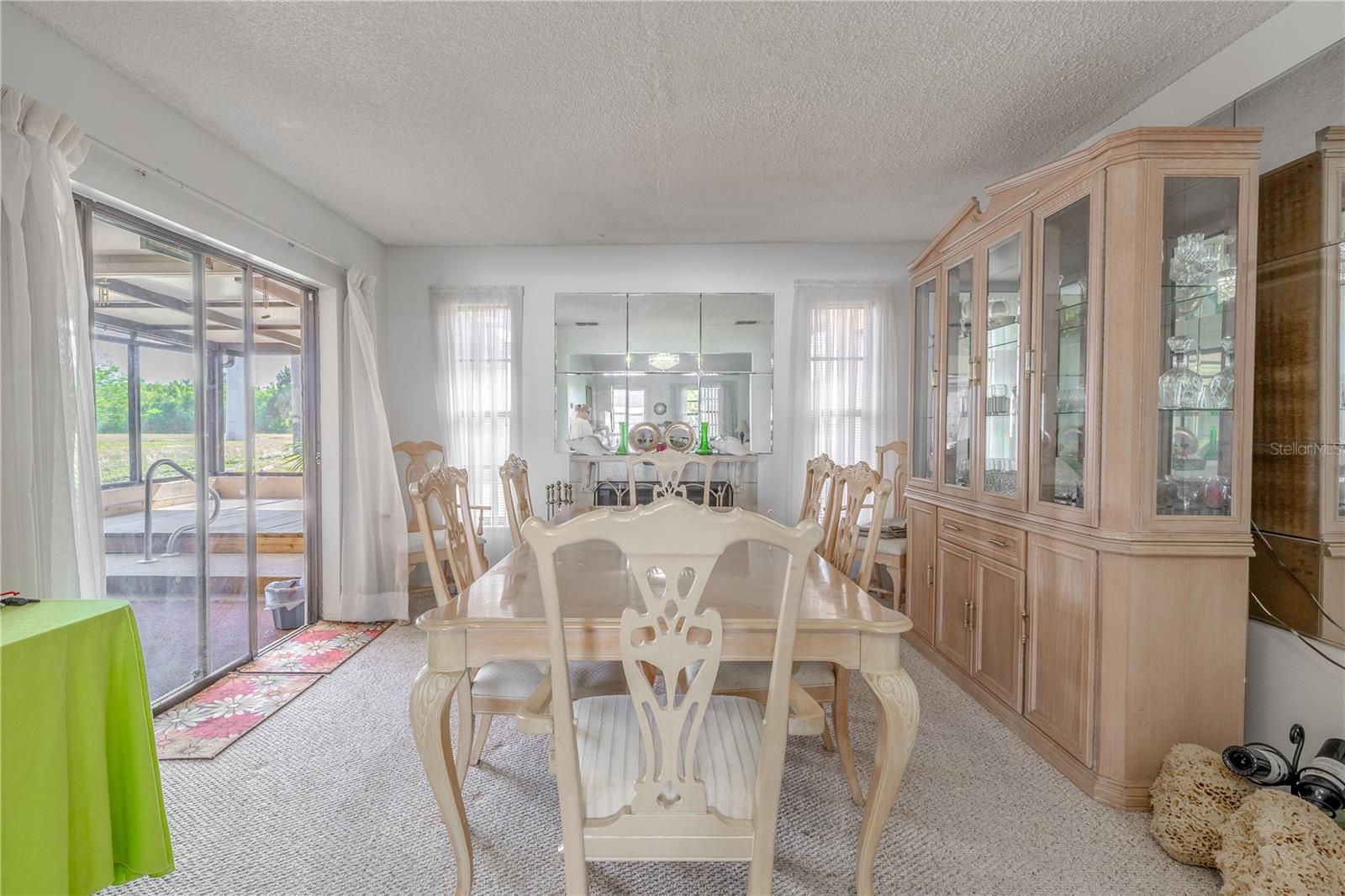 The family room has plenty of natural light, with sliding glass doors and windows that flank the fireplace.