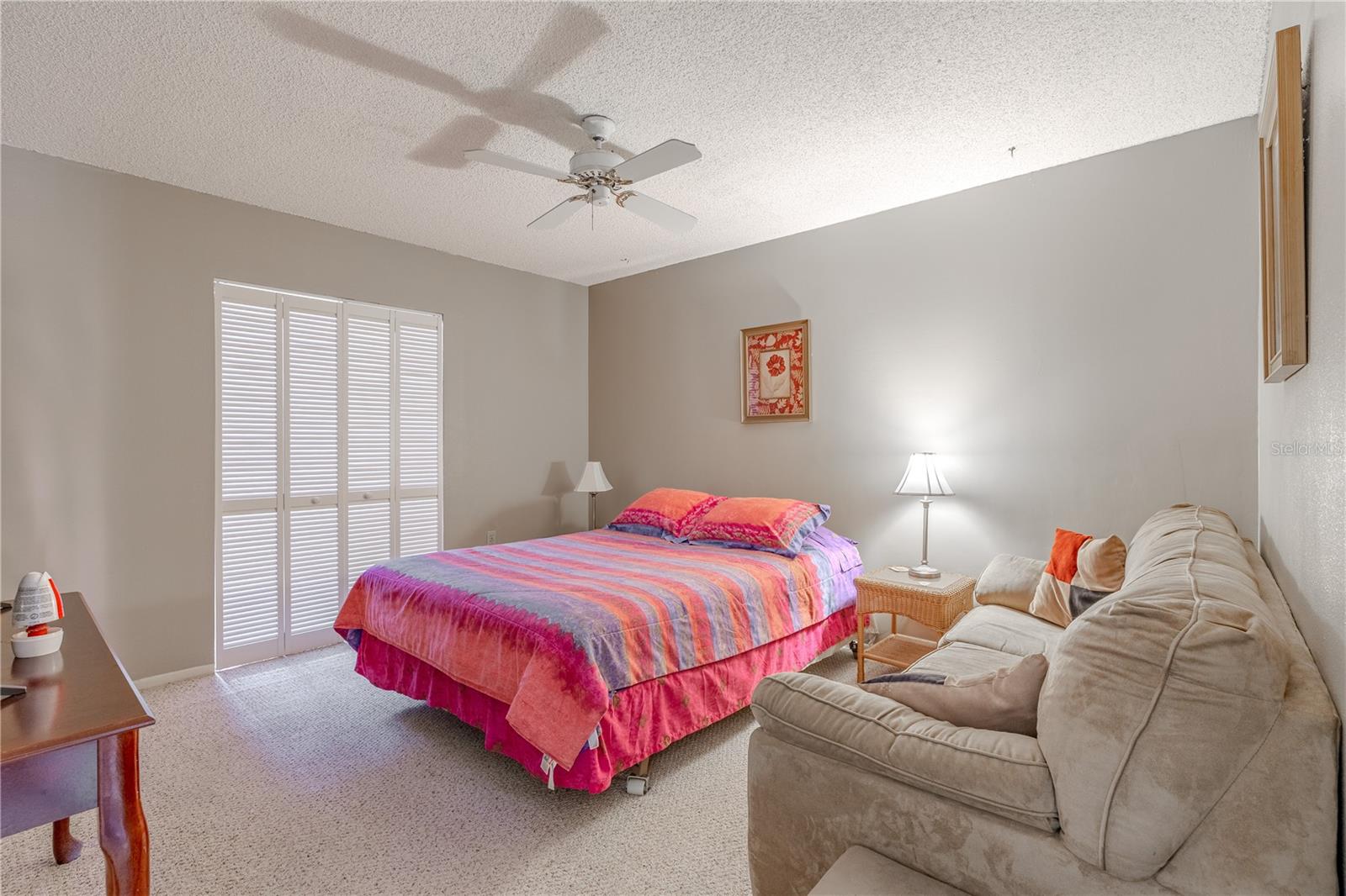 Bedroom 2 features a natural color palette (walls and carpet) and a ceiling fan.