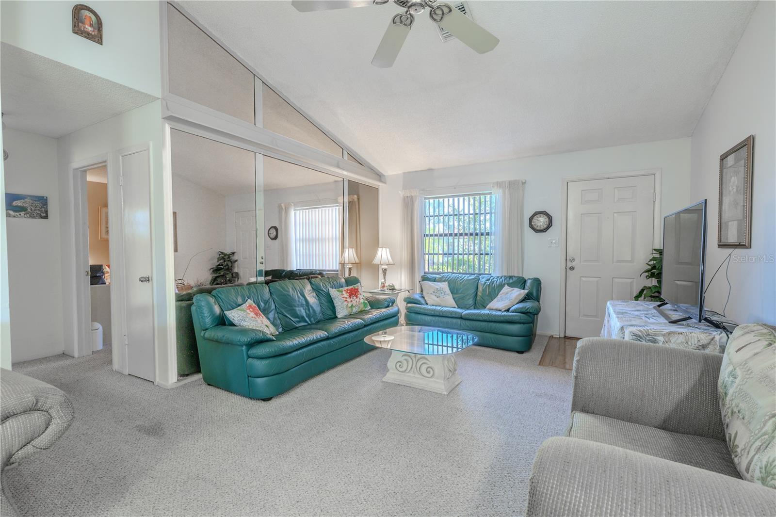 The living room is light and bright and features a mirrored wall.