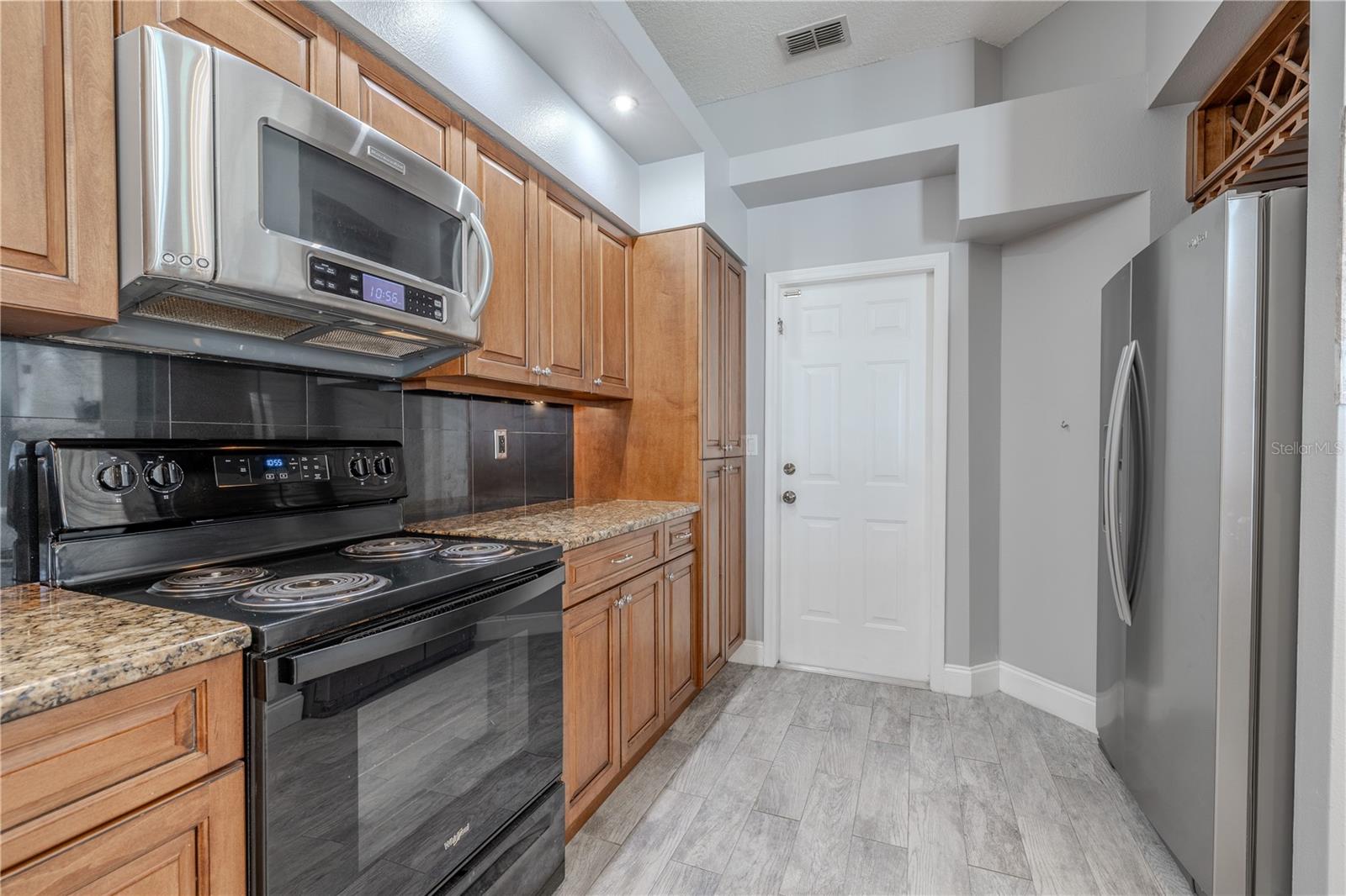 The kitchen has a door to access the garage and a built in wine rack above the refrigerator.