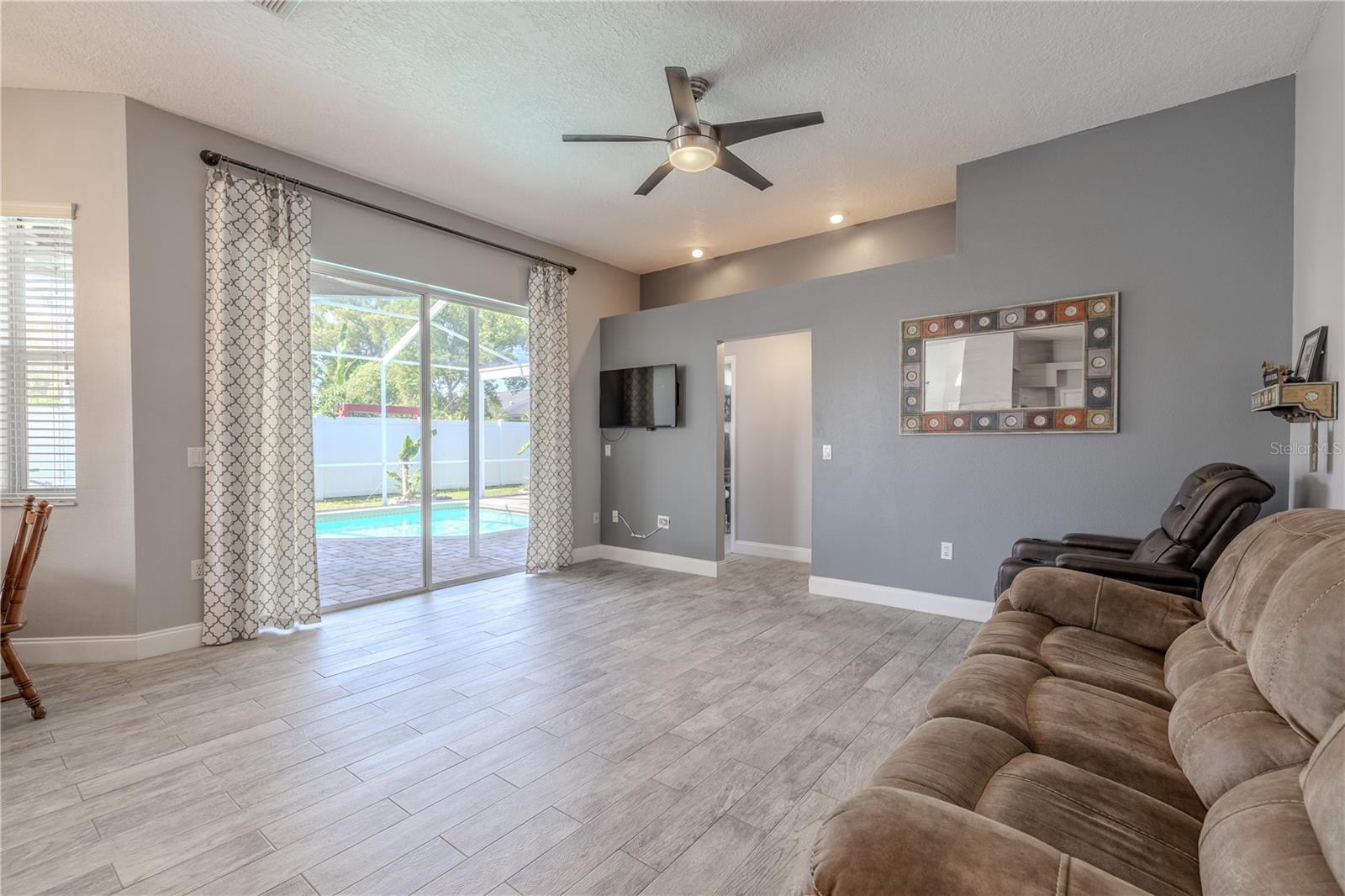 The family room features sliding glass doors that open to the lanai, patio and pool area.