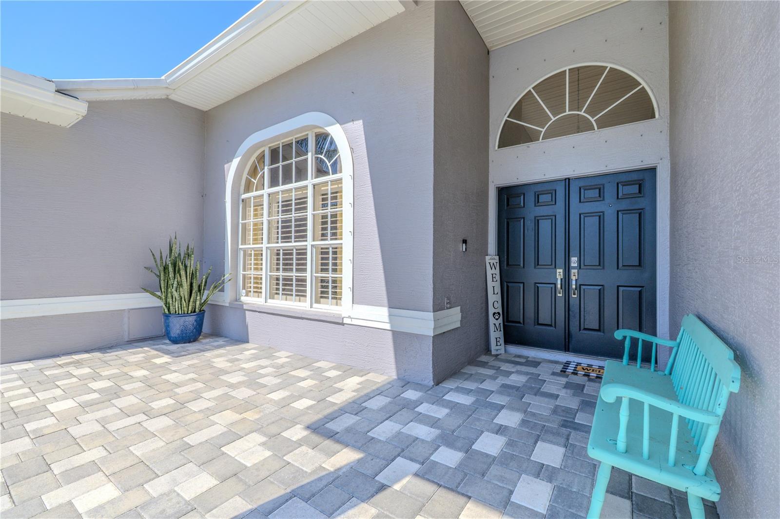Front porch and entryway with double fronts doors and a transom window