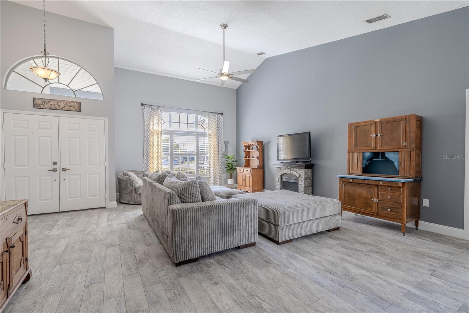The living room gets plenty of natural light from the picture window and transom above the front doors.