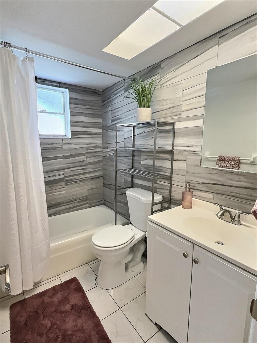 Updated bathroom with bathtub, shower, newer vanity, and space saving medicine cabinet.