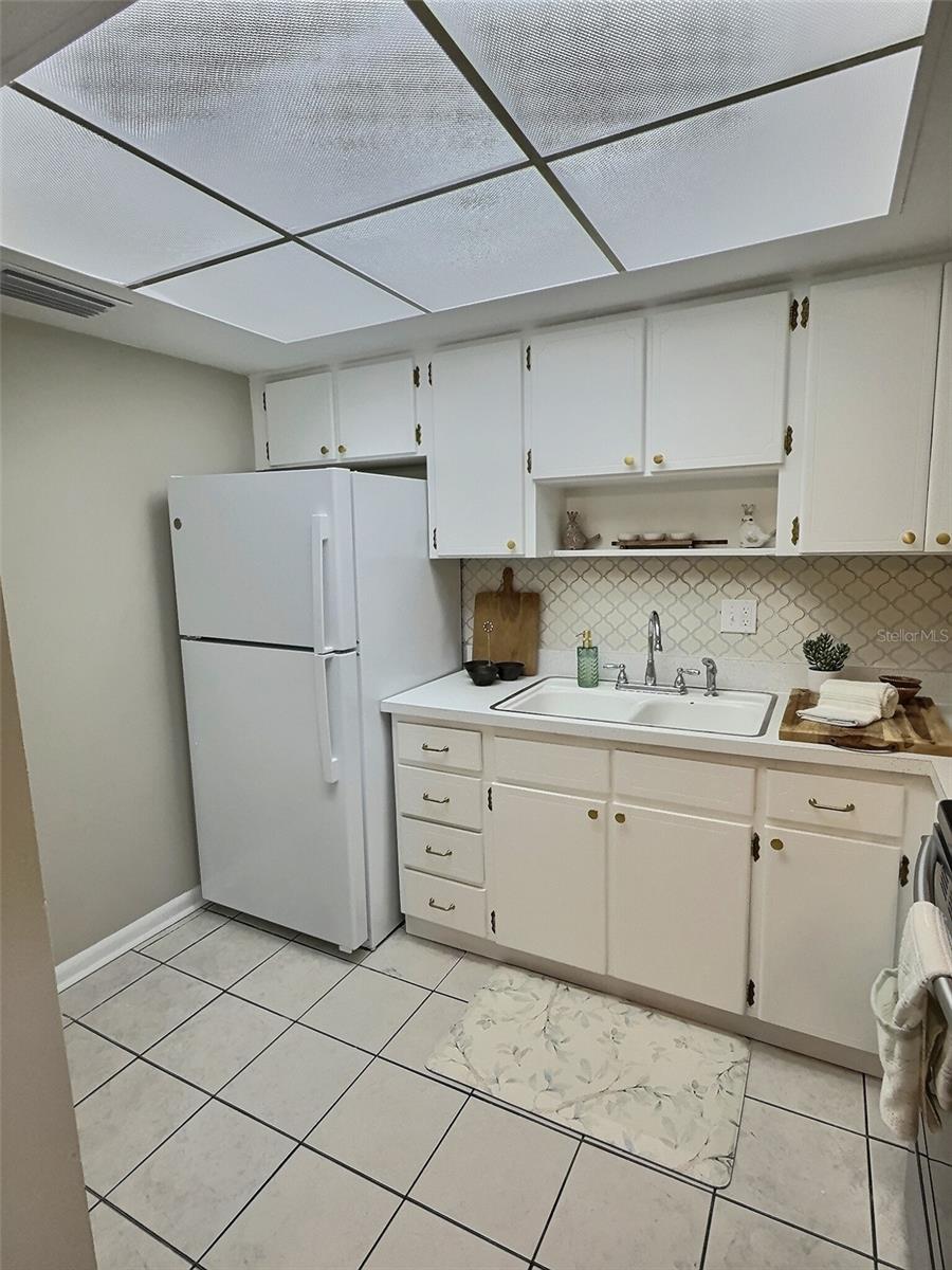 Kitchen with new GE refrigerator and new beautiful arabesque tile backsplash.