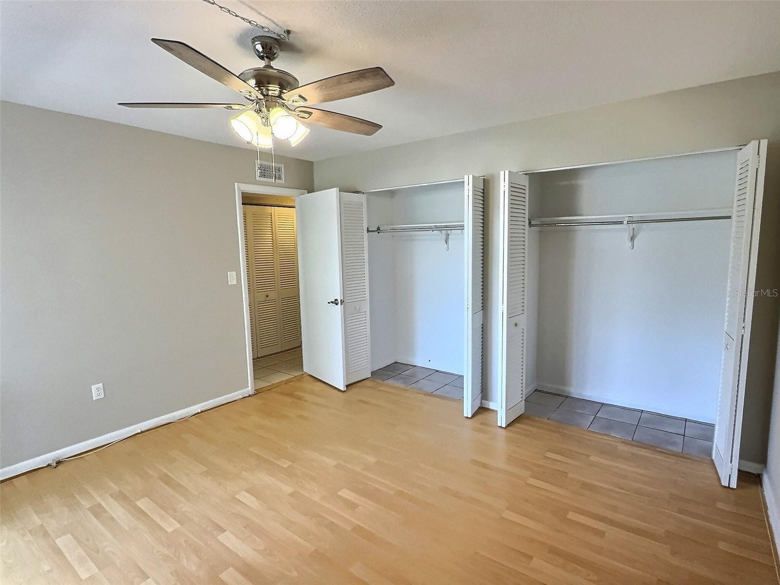 Spacious bedroom with new ceiling fan and double closets.