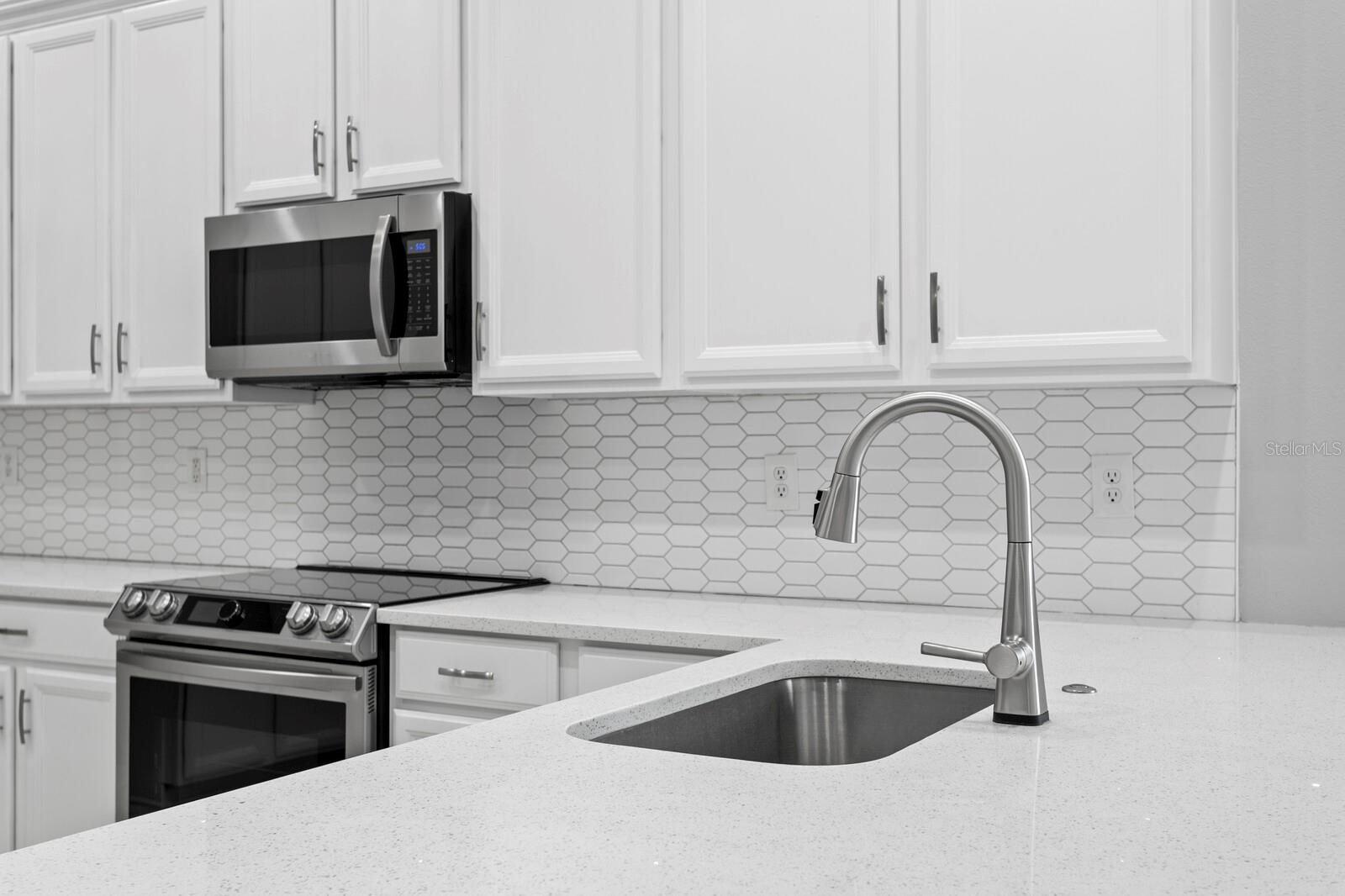You'll love the gleaming new quartz counters and tiled backsplash in the kitchen