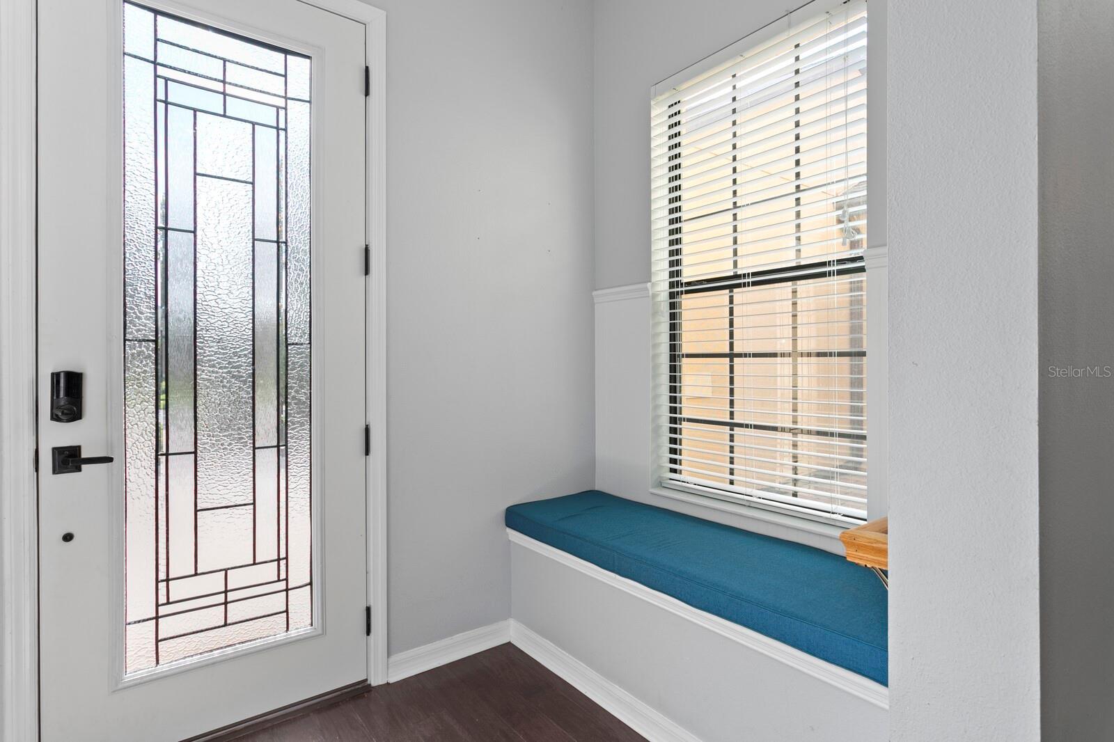 Enter the home through the custom glass entry door and find a built-in bench seat in the foyer