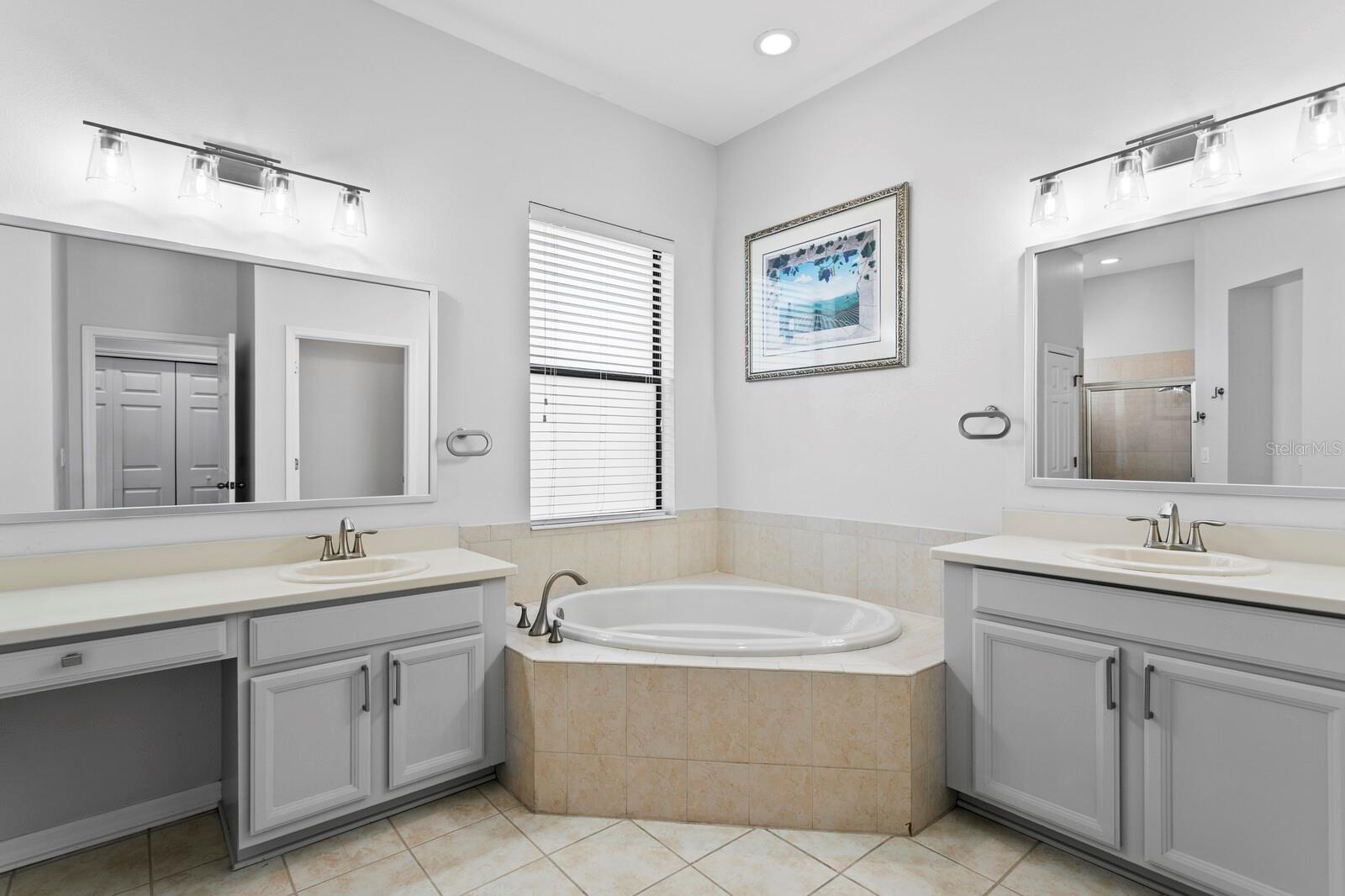 The large primary bath has been updated and includes split vanities