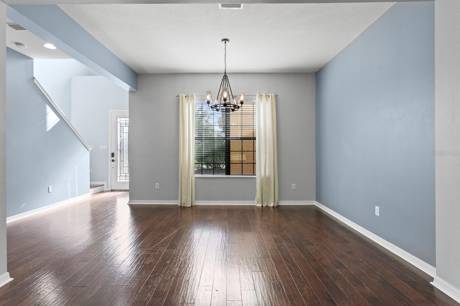 The large formal dining area with oversized windows and views into the private courtyard