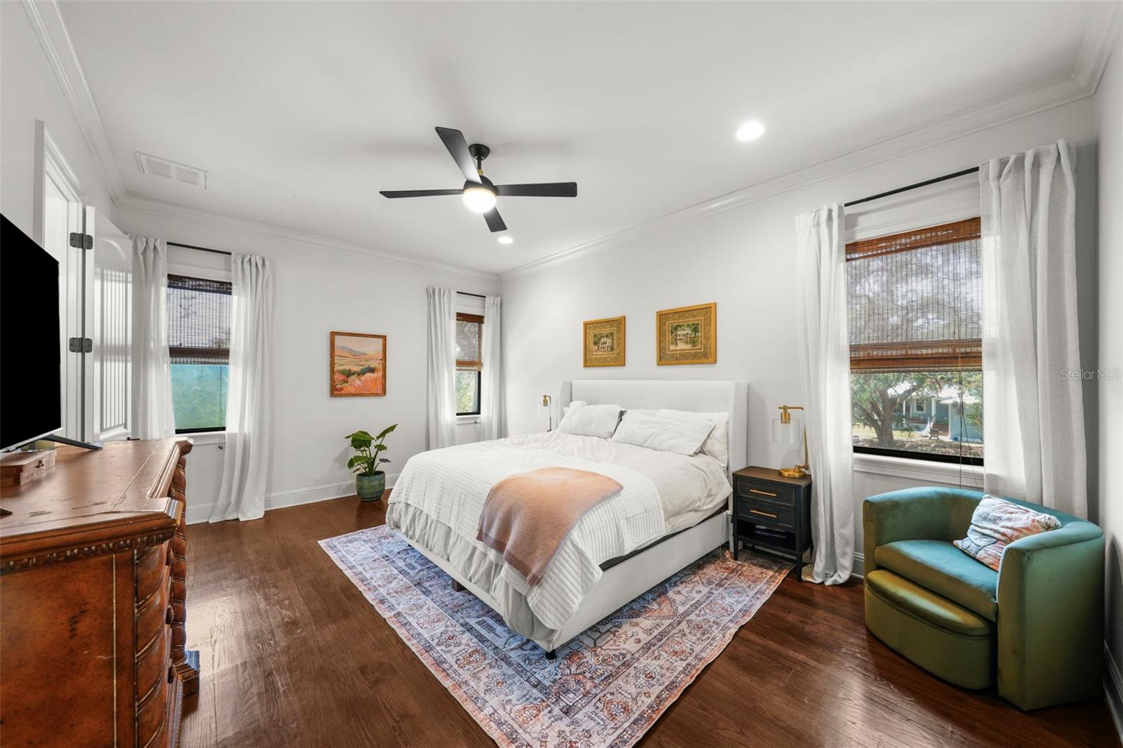 Primary bedroom features high ceilings and multiple windows