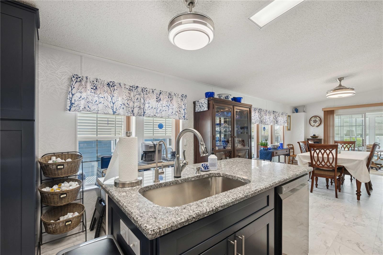 Center island with Granite counter tops, disposal, dishwasher, and a touch faucet in this kitchen.
