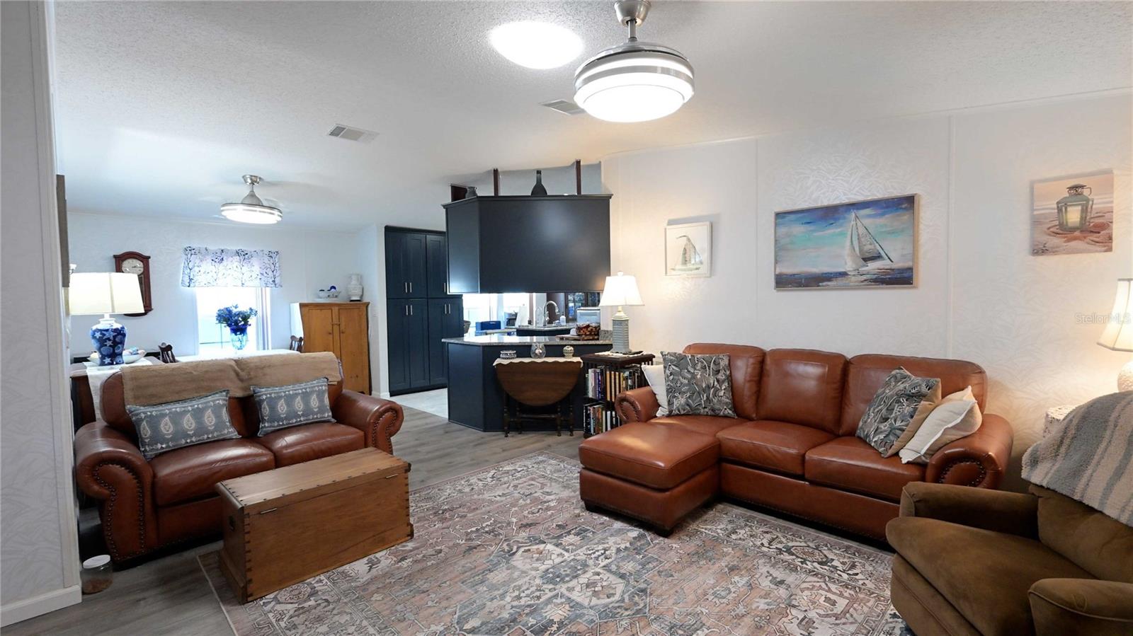 Living room has ceiling fan, laminate flooring, offer ample space for entertaining.