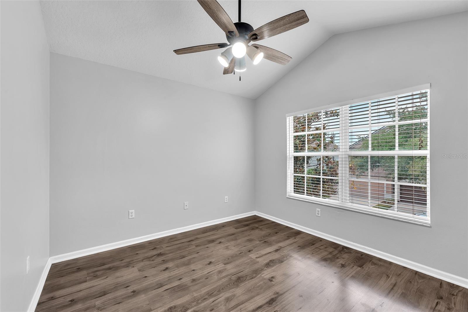 Secondary bedroom #2 offers cathedral ceilings, space and laminate floors and shares a full bathroom.