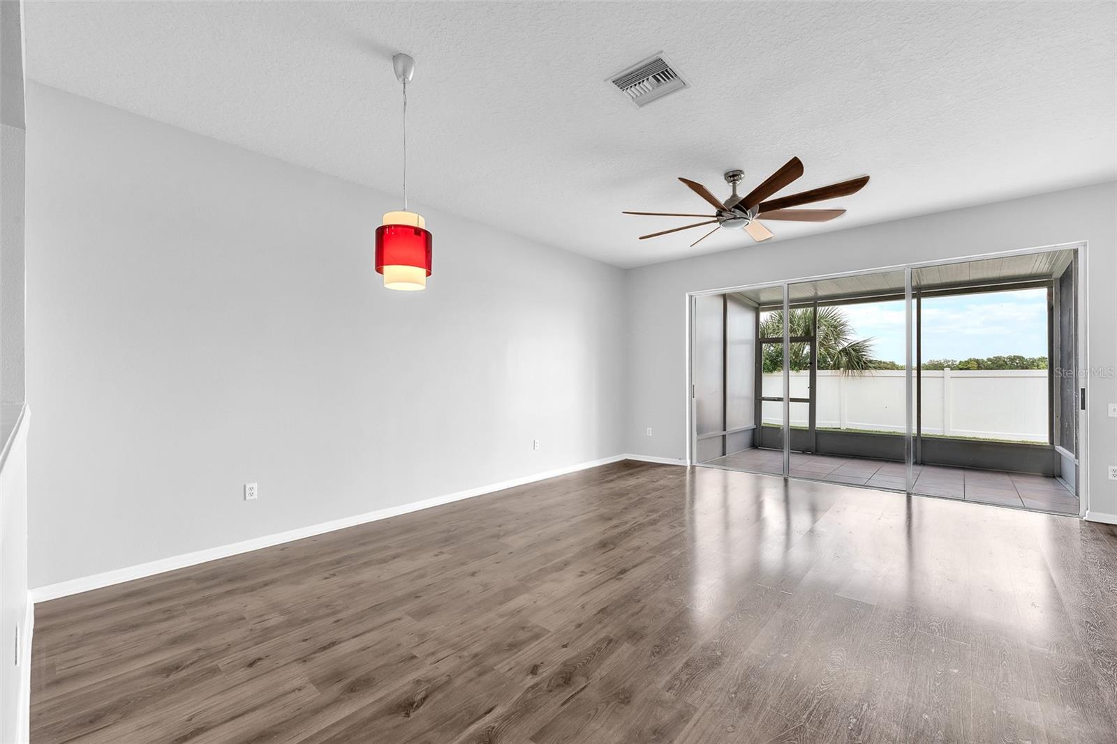 The family room/kitchen is the heart of the home and features high ceilings, plenty of room for furniture, with a sliding glass door leading to a covered/screened lanai perfect for enjoying the great Florida weather and entertaining.