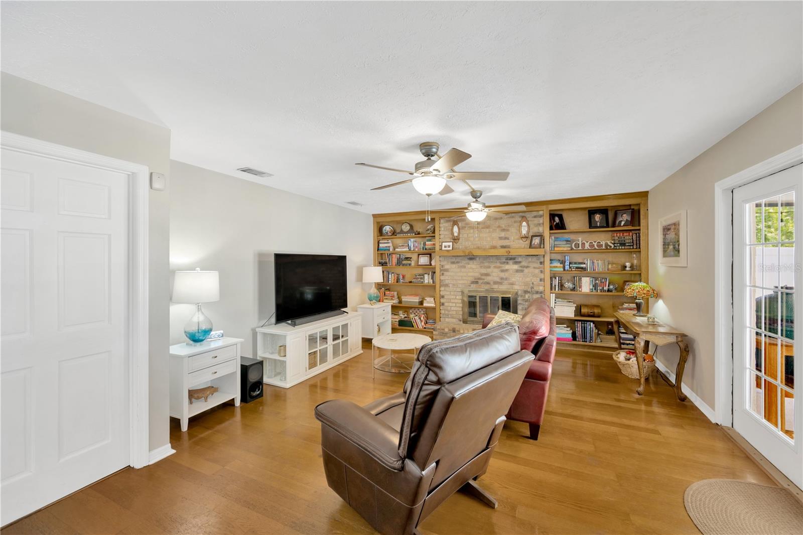 Cozy built-ins flank the charming wood-burning brick fireplace, and elegant French doors lead out to your private backyard retreat.