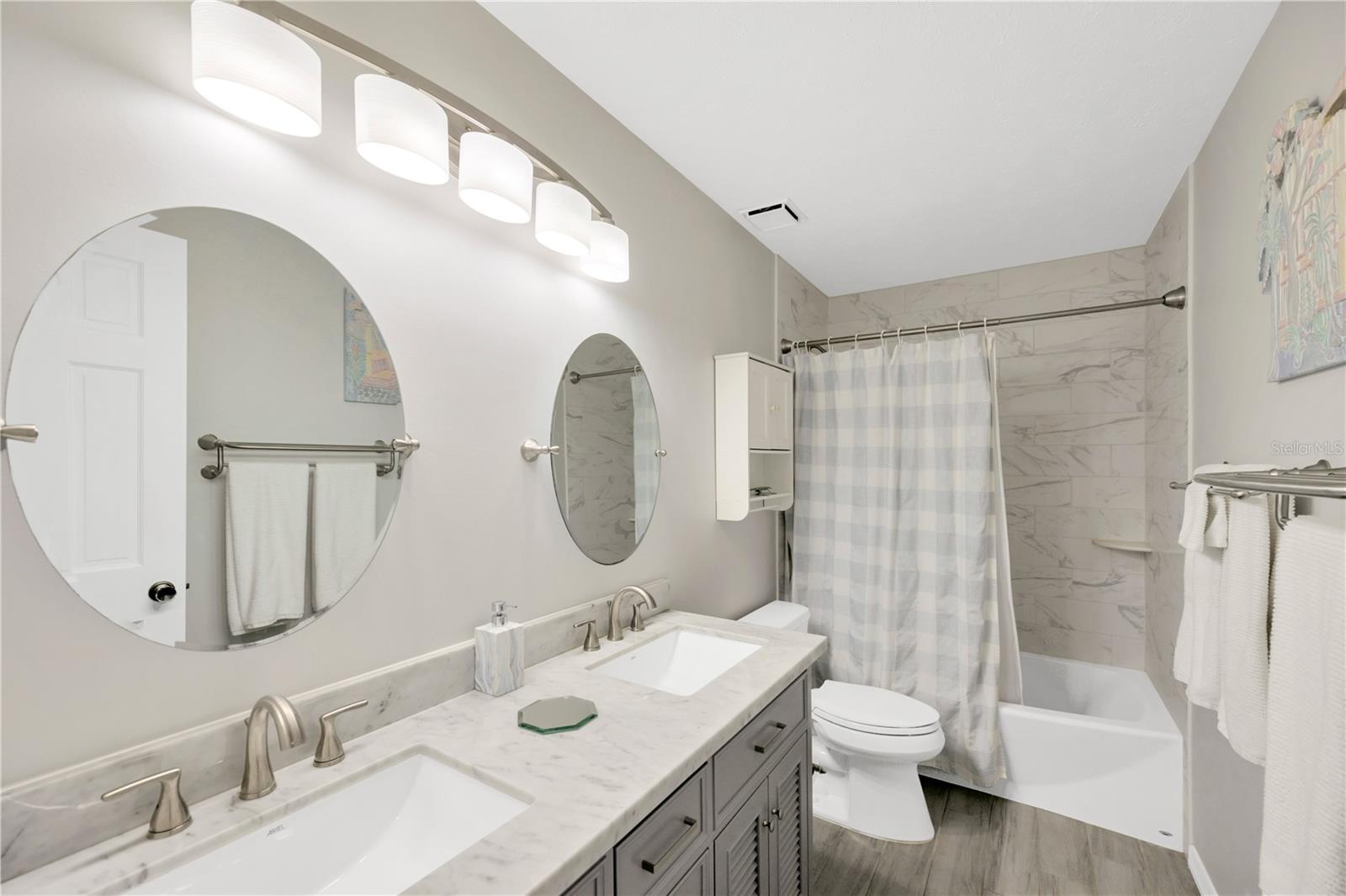 The recently remodeled second bathroom upstairs has long vanity with two sinks and a tub/shower combination.