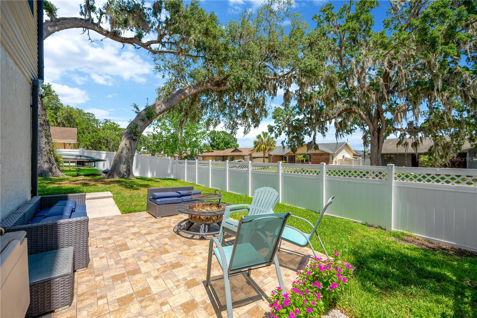 The fenced backyard offers a tranquil, private space with mature landscaping and a sunny side patio—perfect for relaxing or entertaining.