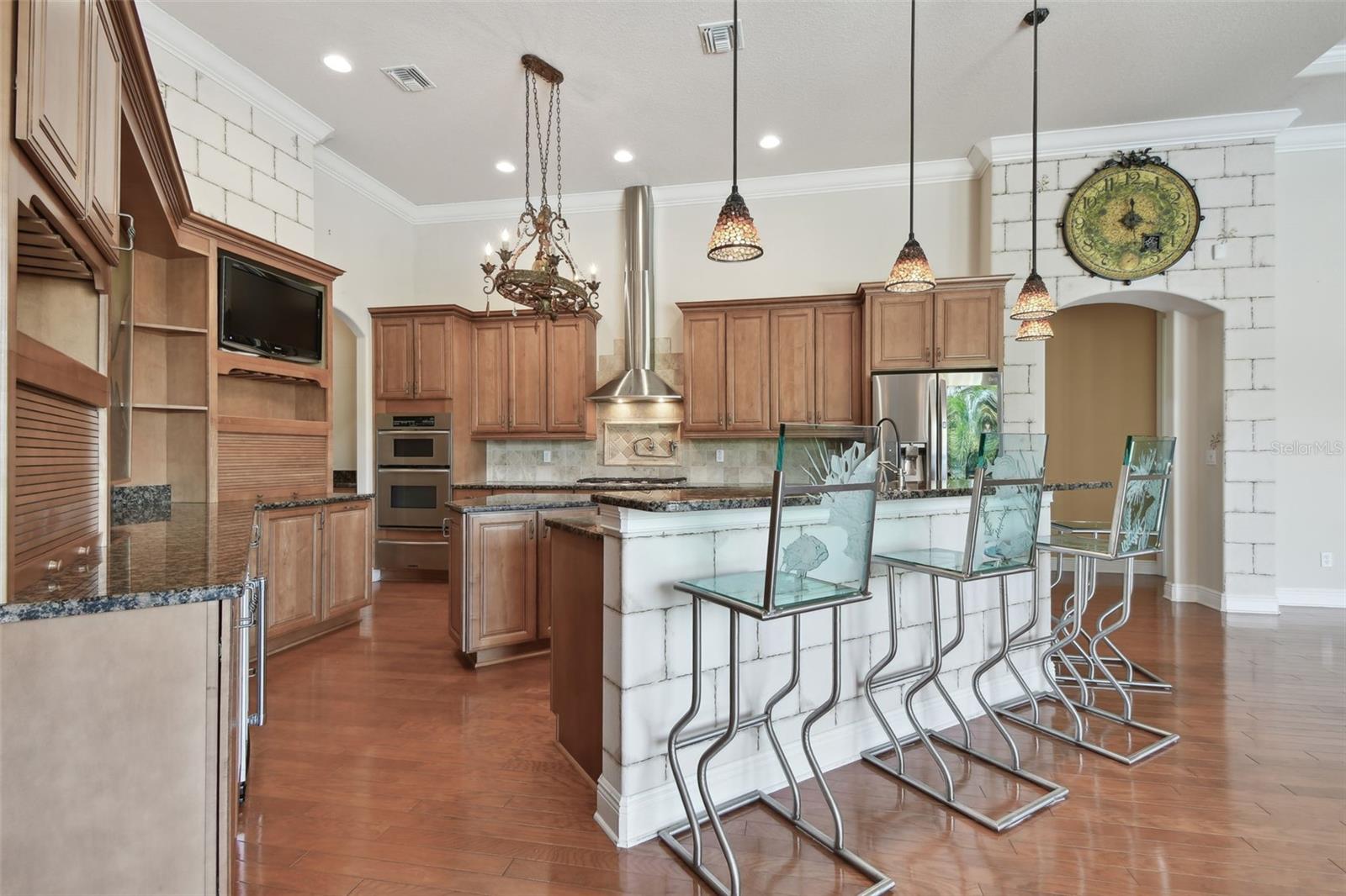 Kitchen with island, and breakfast bar adjacent to the family room and breakfast area.