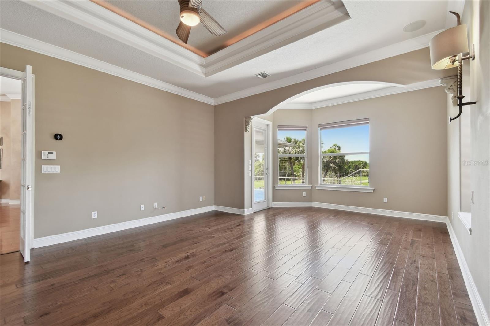 The primary bedroom has volume ceiling and a door to the pool area.