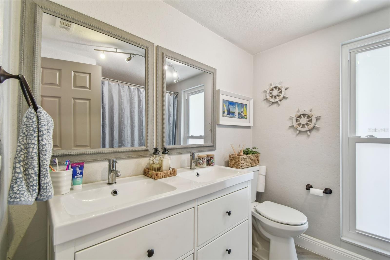 2nd bath - completely remodeled. Now tile floor, vanity, mirrors, plumbing fixtures and lighting.